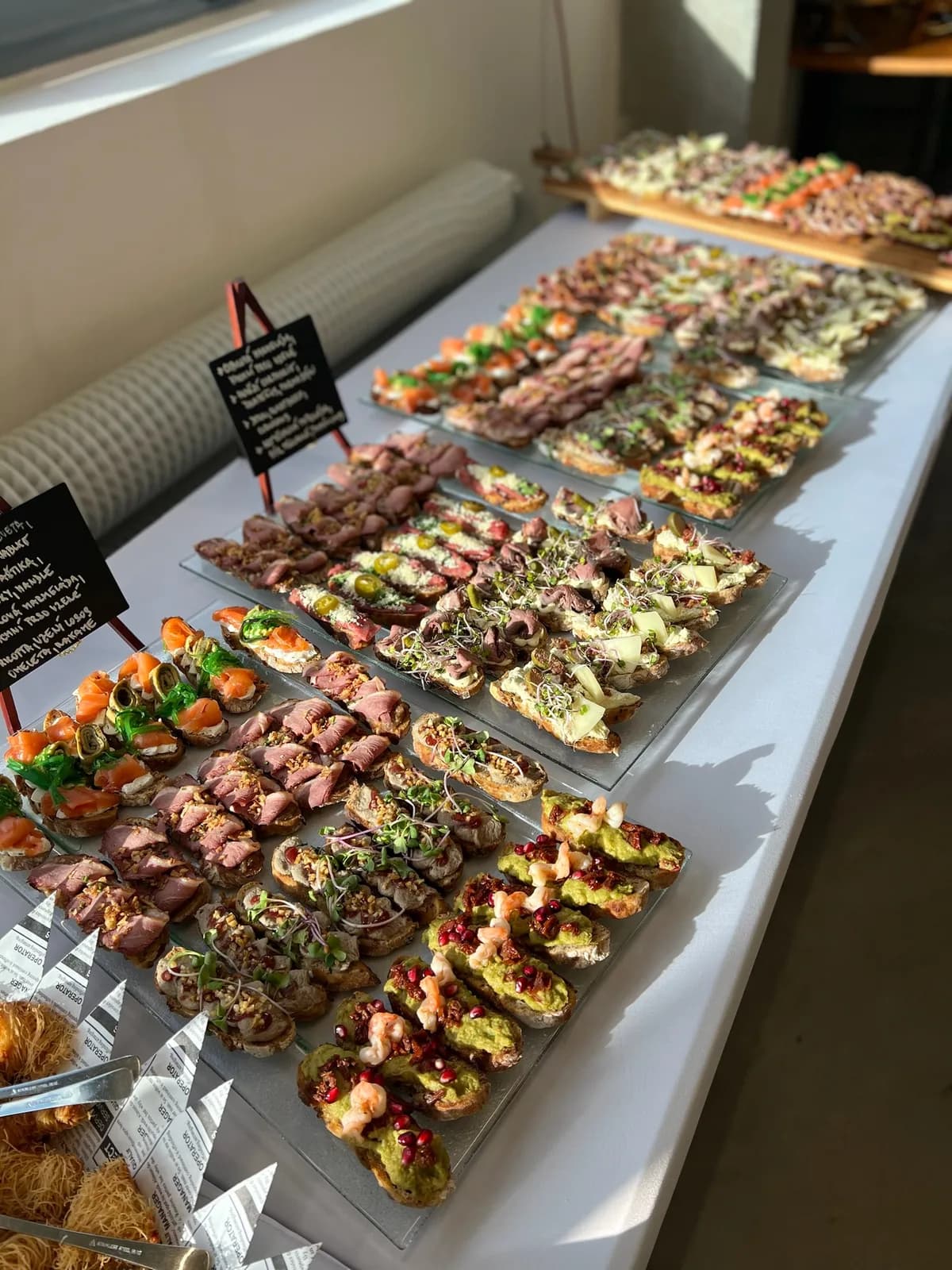 Dlouhý firemní rautový stůl plný pintxos