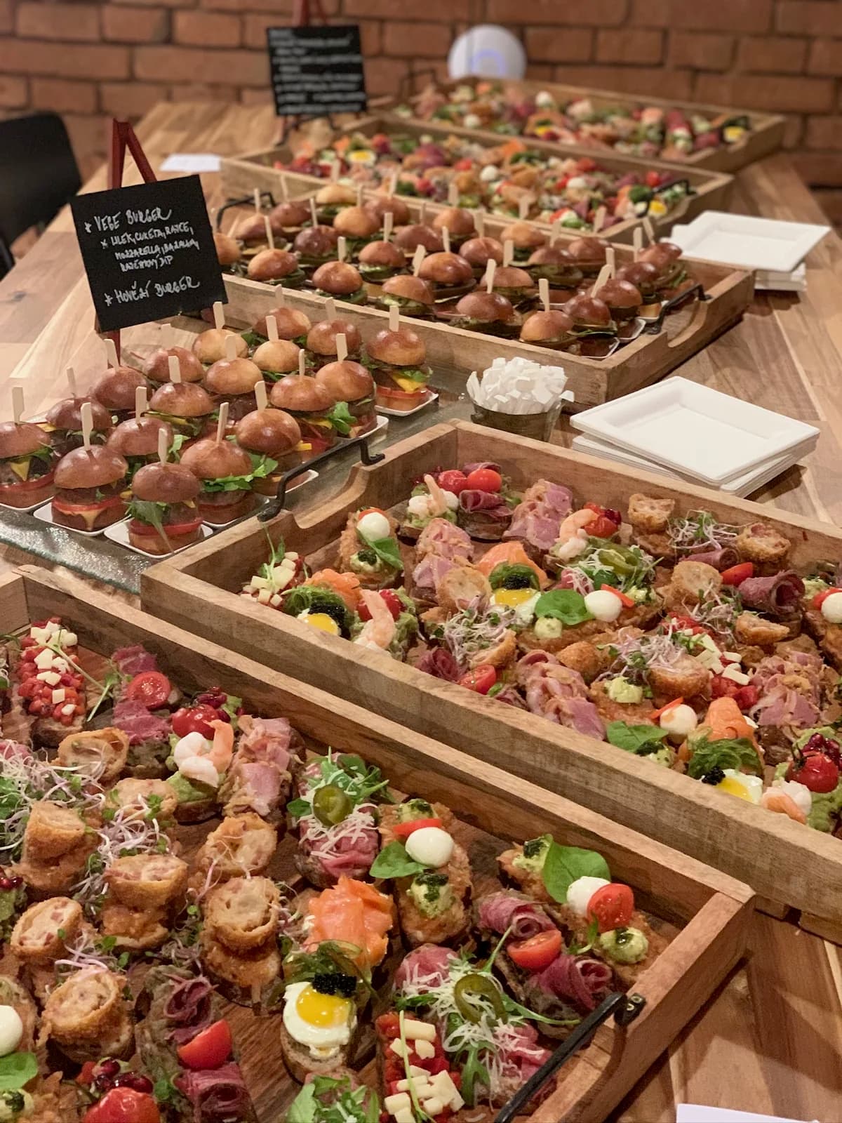Dřevěné podnosy s mini burgery a pintxos